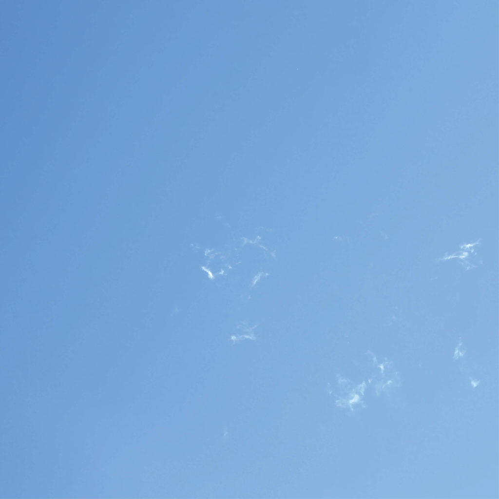 Square image of blue sky with clouds